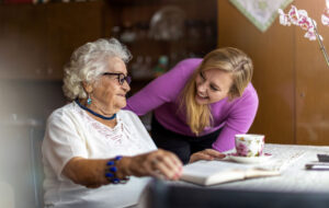 Young woman spending time with her elderly grandmother at home