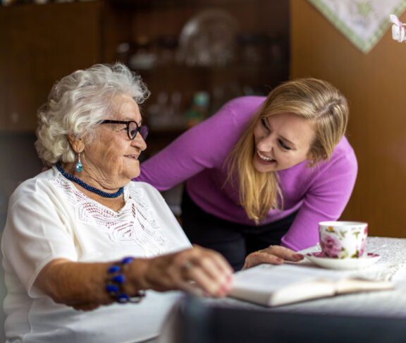 Young woman spending time with her elderly grandmother at home