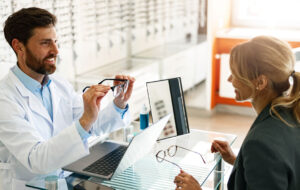 An ophthalmologist consults a client at his workplace in an optician's shop