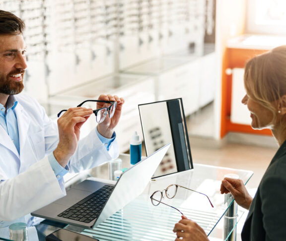 An ophthalmologist consults a client at his workplace in an optician's shop