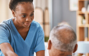 Help, support and medical with nurse and old man for retirement, rehabilitation or healing. Empathy, physical therapy and healthcare with patient and black woman in nursing home for caregiver service