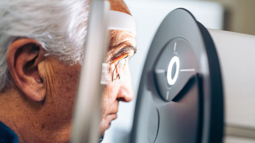 Elderly patient receives a glaucoma screening using a laser eye scanner.