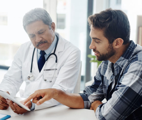 Cropped shot of a mature male doctor and patient having a discussion in the doctor's office before a checkup