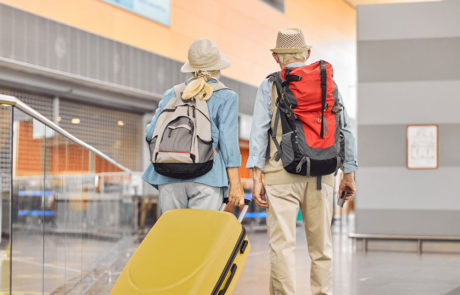 Two Caucasian elderly travelers standing at the airport