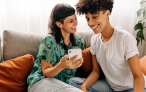 Two lesbian lovers using a smartphone together at home