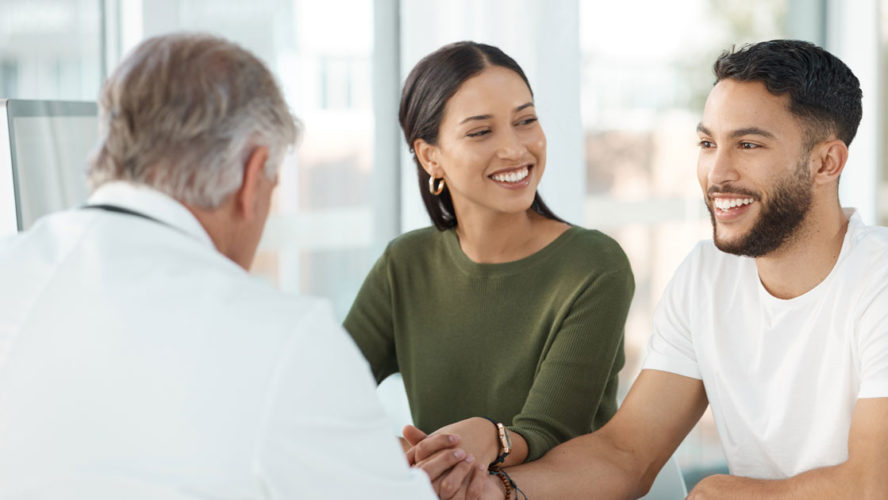 Shot of a young couple sitting with their obstetrician and holding hands during a consultation in the clinic