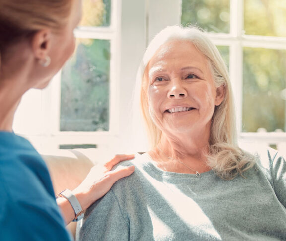Shot of a senior woman being supported by her nurse at home