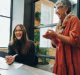 Group of successful businesspeople laughing cheerfully during an office meeting. Team of multicultural businesspeople collaborating in a creative workplace.