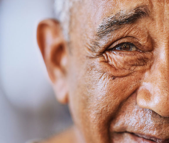 Portrait of a happy, kind black senior mans face with wrinkles, smile and friendly in a retirement home.