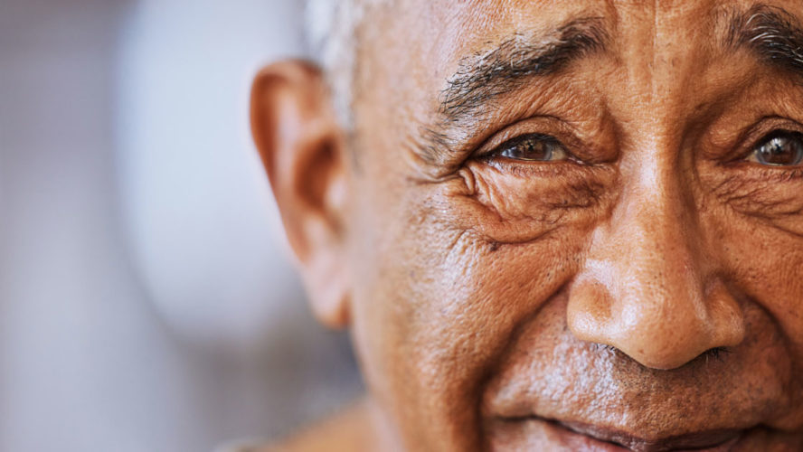 Portrait of a happy, kind black senior mans face with wrinkles, smile and friendly in a retirement home.