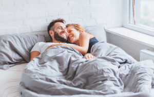 A lovely young couple enjoying bedtime in the morning.