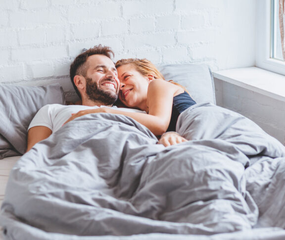 A lovely young couple enjoying bedtime in the morning.