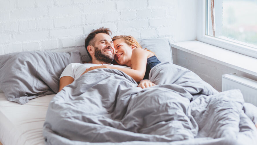 A lovely young couple enjoying bedtime in the morning.