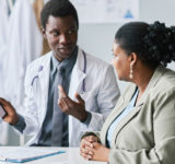 Side view portrait of a woman listening to doctor in clinic
