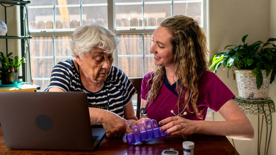 A young nurse is explaining an elderly woman's daily medications to her.
