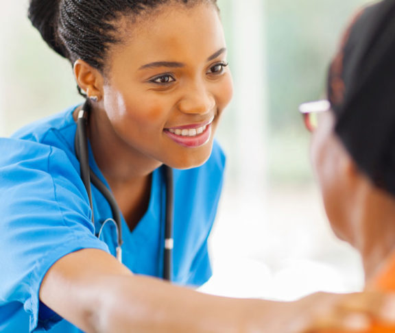 African medical nurse comforting senior patient