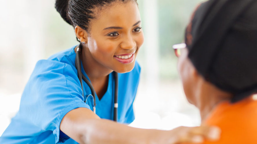 African medical nurse comforting senior patient