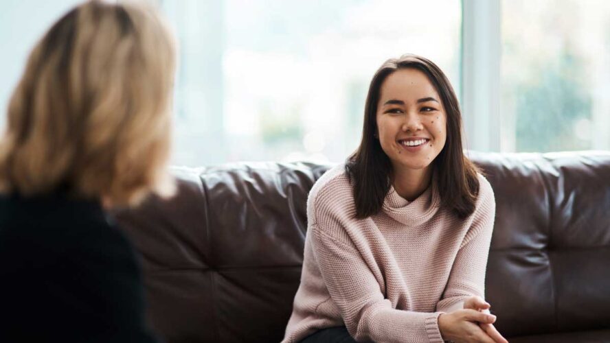 Therapy, happy women have a conversation on sofa and speaking or talking with a psychologist. Mental health or communication, support or consulting and people on couch have a discussion together