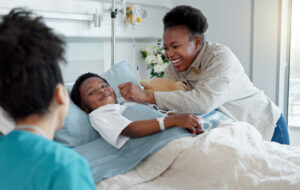 Mom, nurse and black child patient in hospital for recovery of surgery for congenital heart disease. Checkup, sick and cardiology medical worker with happy mother and kid for postoperative care