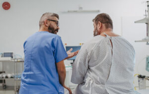 Supportive doctor soothing a worried overweight patient, discussing test result in emergency room. Illnesses and diseases in middle-aged men's health. Compassionate physician supporting stressed