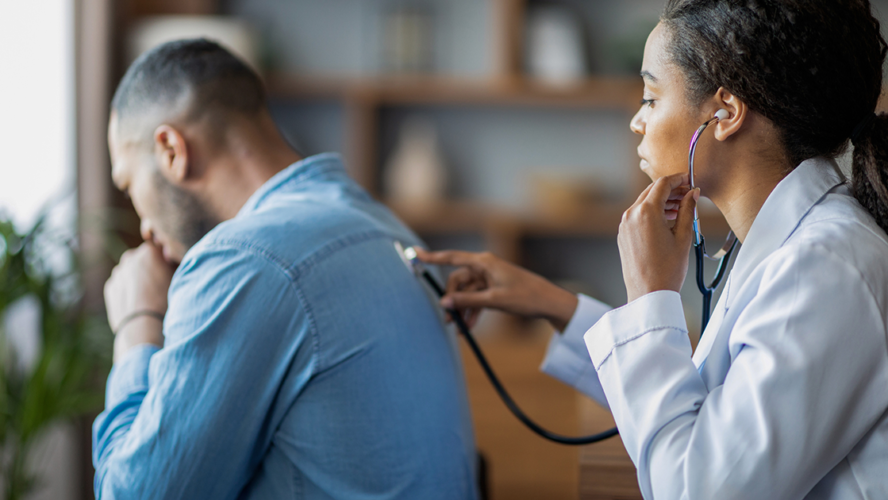 general practitioner checking sick man lungs with stethoscope
